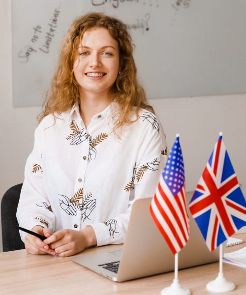 Close-up portrait of a beautiful smiling student on bright background. Happy ginger female teacher smiling to her colleagues