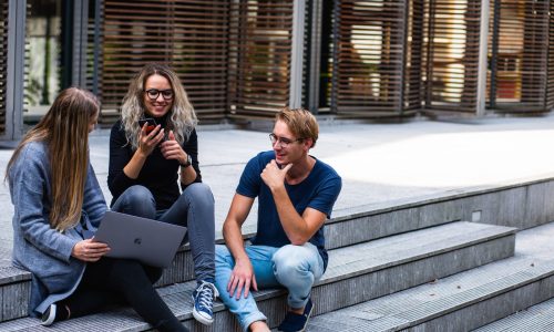 three-persons-sitting-on-the-stairs-talking-with-each-other-1438072