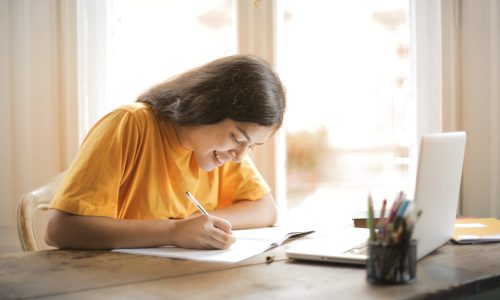 woman-in-yellow-shirt-writing-on-white-paper-3807755