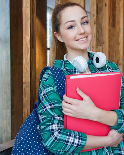 woman-standing-in-hallway-while-holding-book-1462630